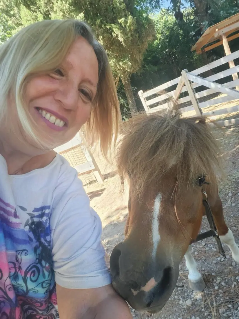 Beatriz junto a su caballo, al aire libre