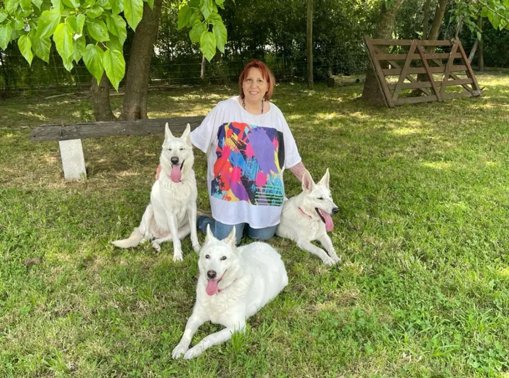 Beatriz en el jardín junto a sus tres perros blancos