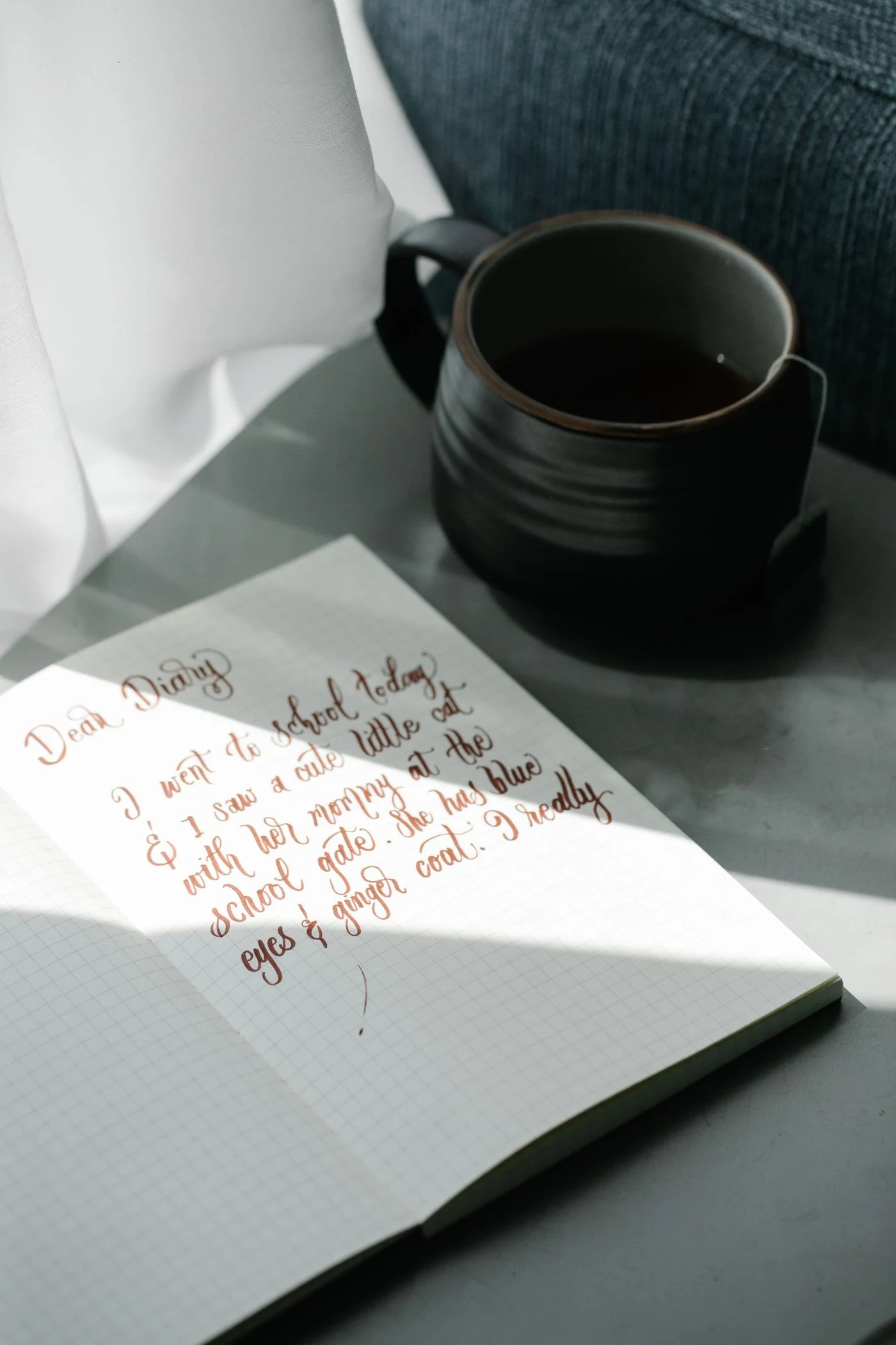Cuaderno de escritura junto a una taza